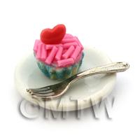 Miniature Pink Sprinkle Cupcake In A Blue Paper Cup On A Plate With A Fork