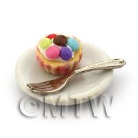 Miniature Smartie Topped Cupcake In An Pink Paper Cup On A Plate With A Fork