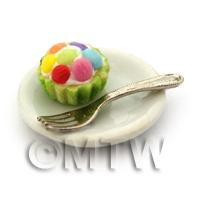 Miniature Smartie Topped Cupcake In A Green Paper Cup On A Plate With A Fork