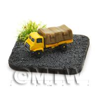 yellow painted light lorry on a tarmac style base left hand view